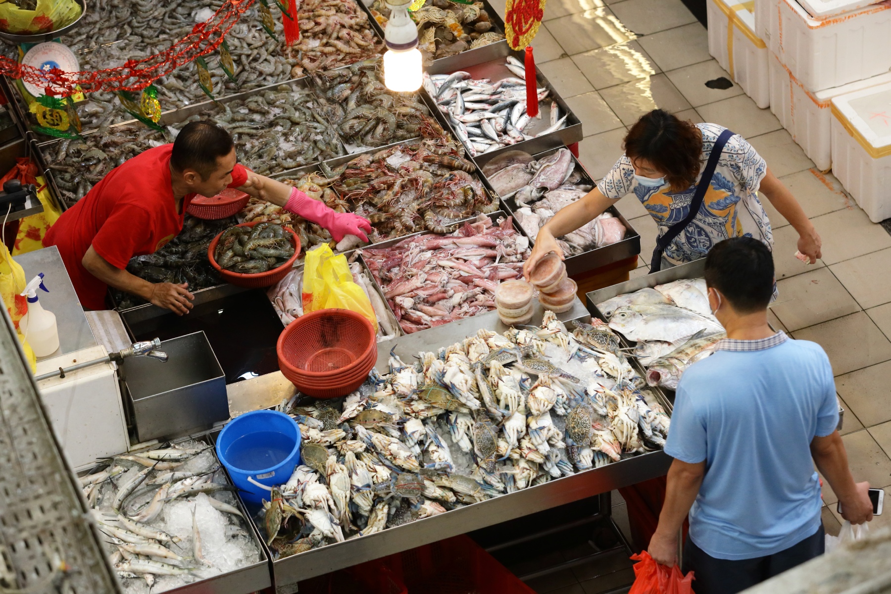 Customers buying fresh fish from a food market