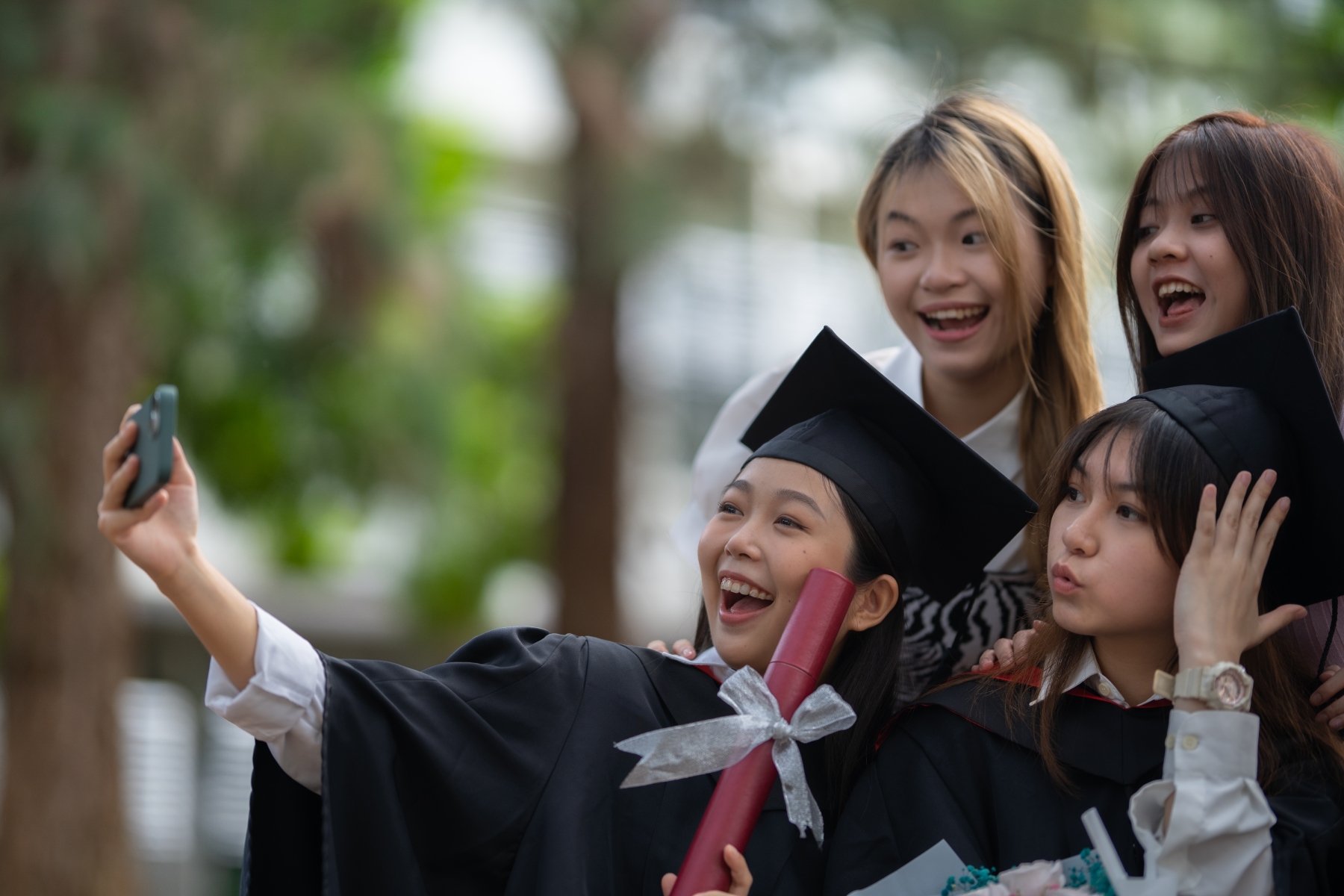 Graduant takes a funny selfie with her three friends in a garden