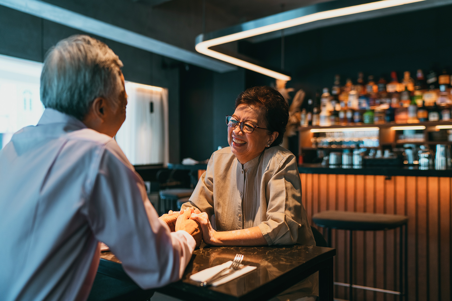 A retired couple on a date in a pub or at a restaurant - pensioners are eligible for more vaccines in Singapore
