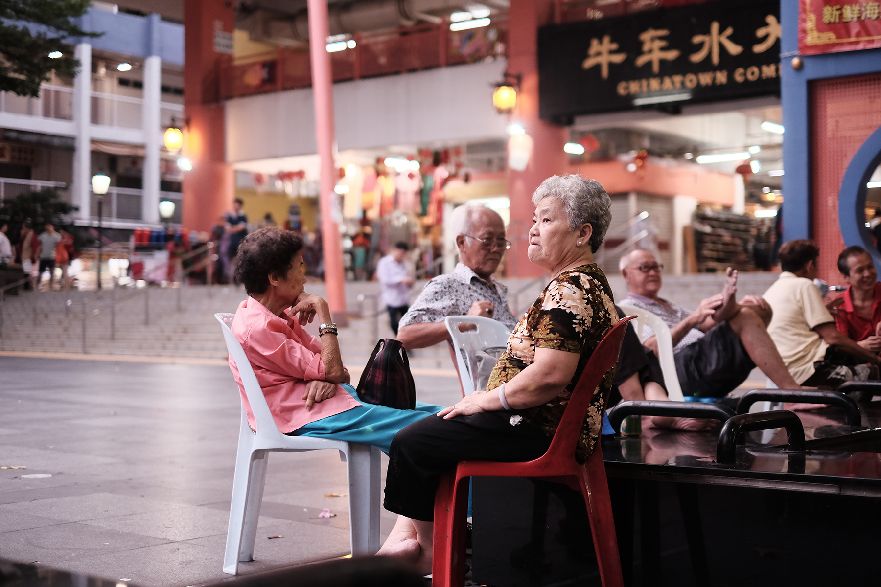 Retirees relaxing in Kreta Ayer Square in Singapore, a group of two women and two men

