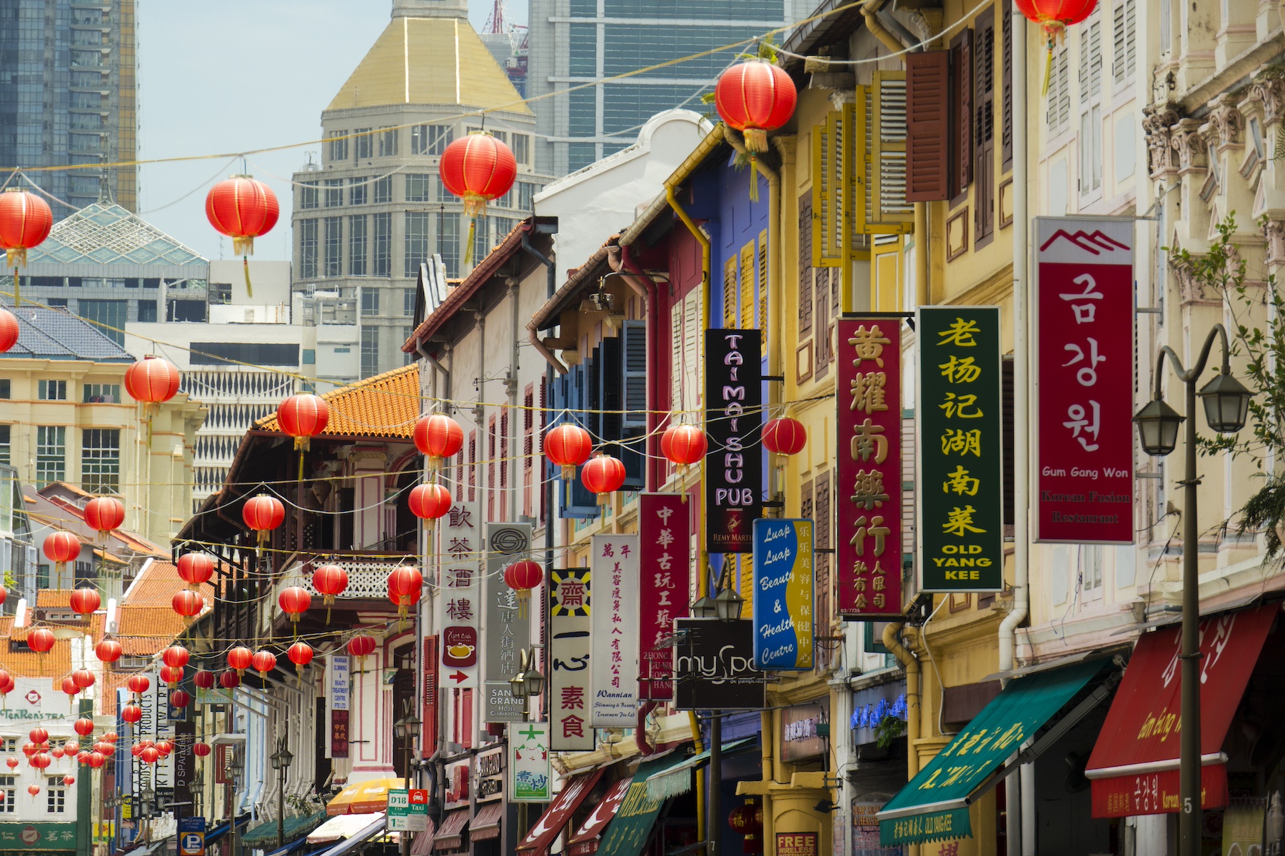 A street in Singapore's Chinatown lined with signs in Chinese and red paper lanterns