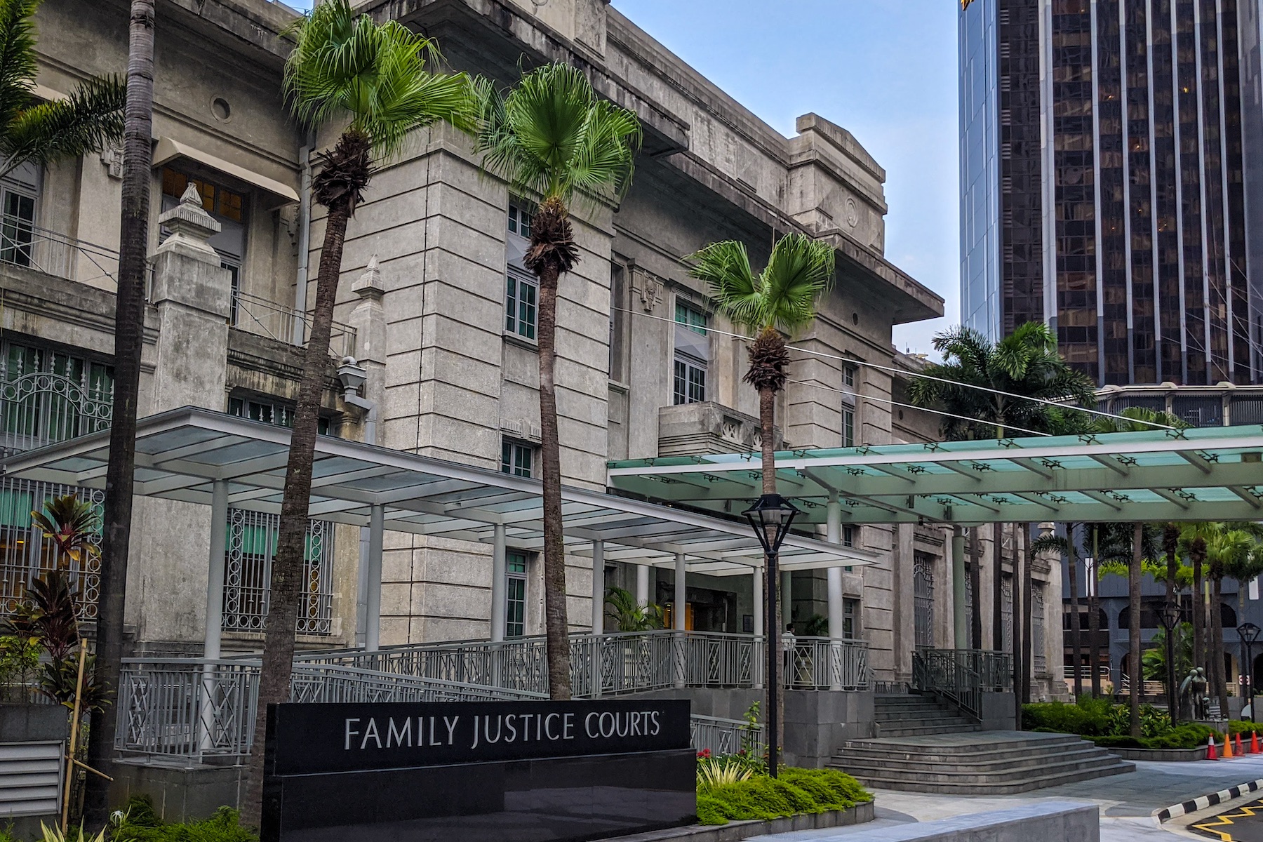 The main entrance to Singapore's Family Justice Courts is shown with a glass awning for approaching visitors and vehicles