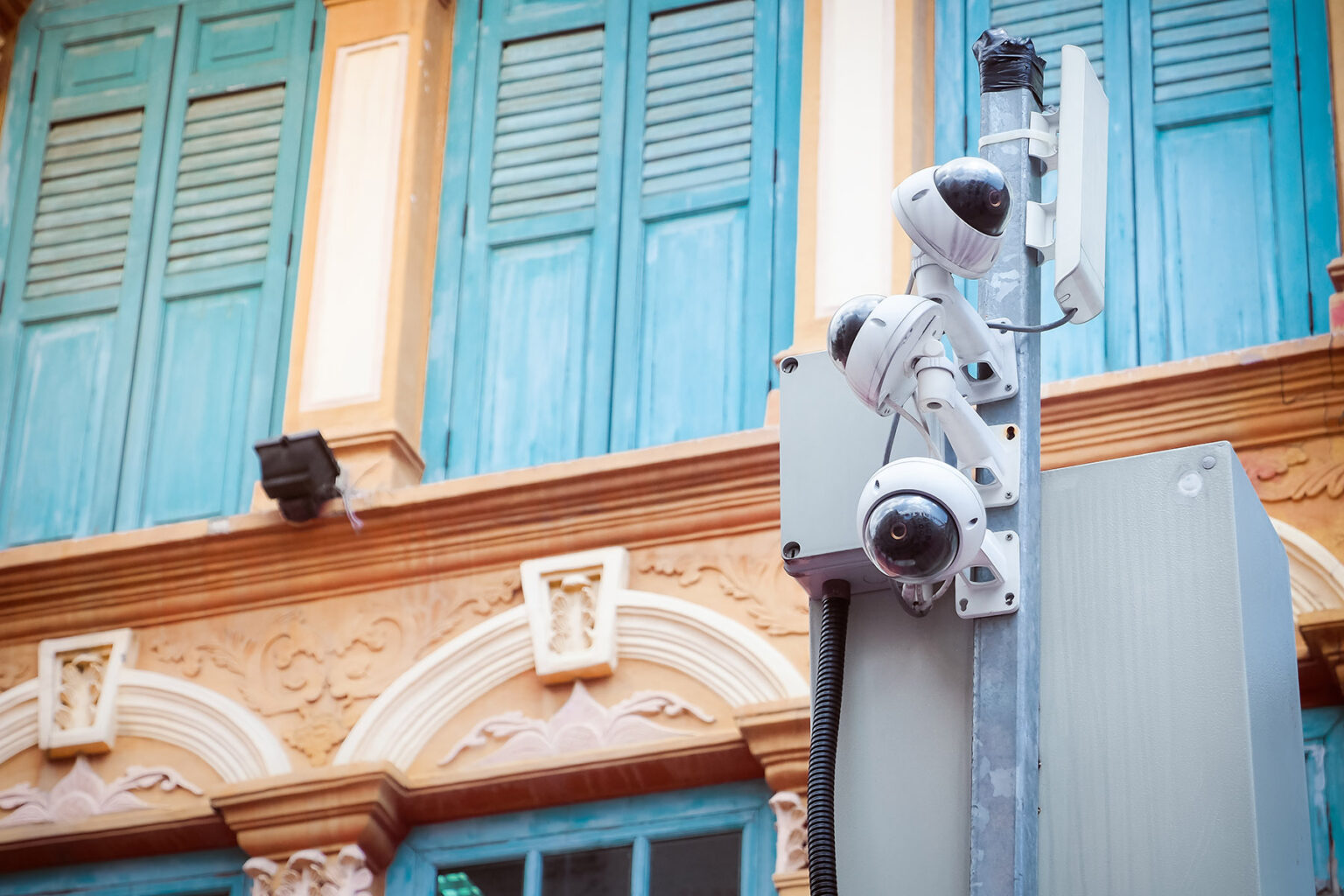 CCTV camera security in Singapore, with brightly colored buildings in the background.