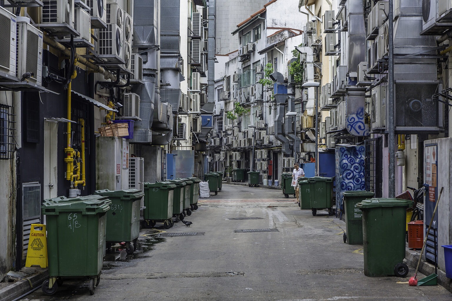 Empty back alley of Circular Road in Boat Quay, Singapore. Loads of green garbage containers are ready for picking up.