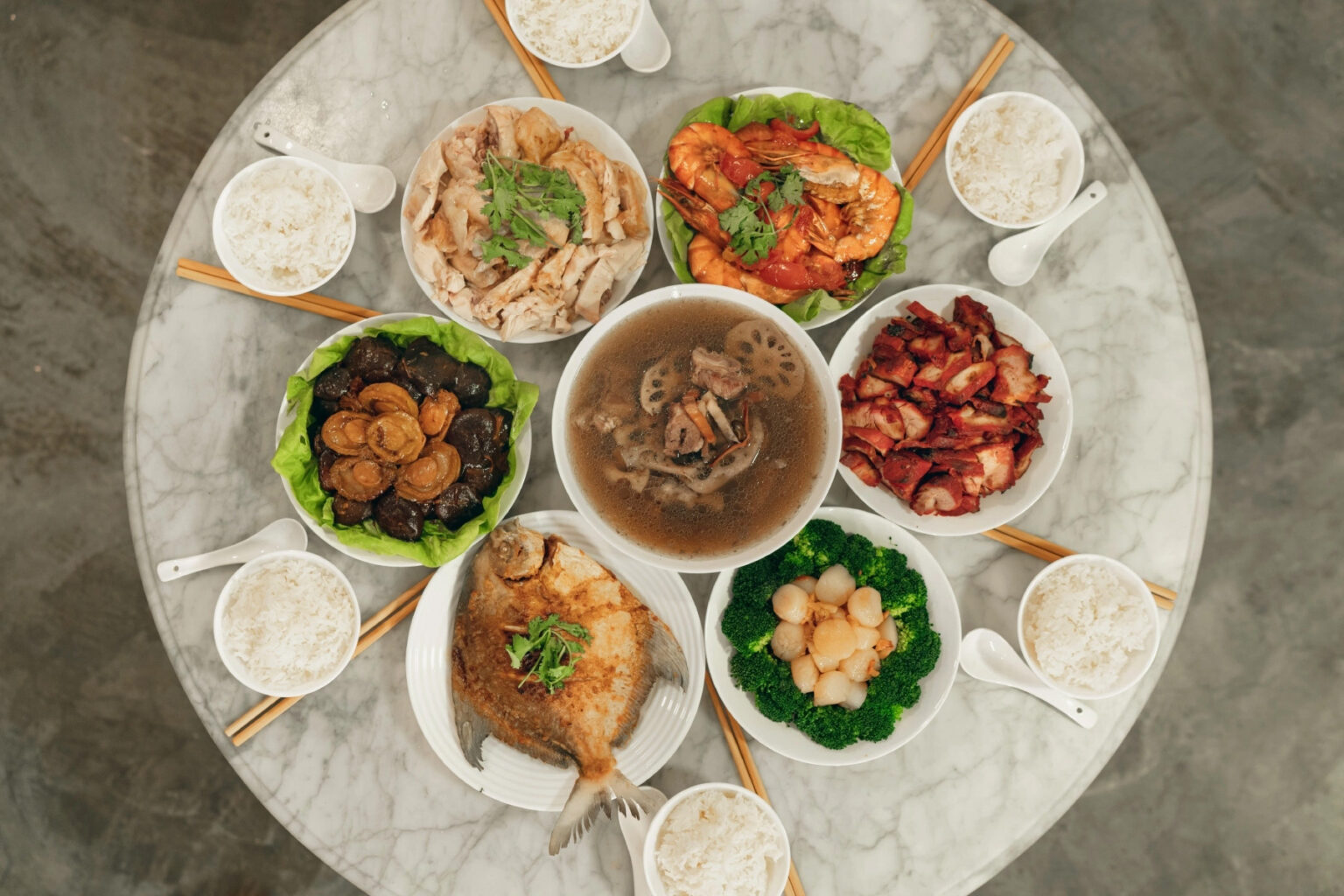 A Lunar New Year dinner spread with various Singaporean dishes on a circular table