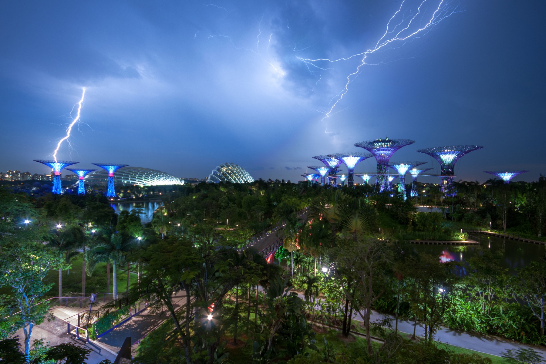 Lightening bolts in the sky during a thunderstorm over Garden by the Bay in Singapore.