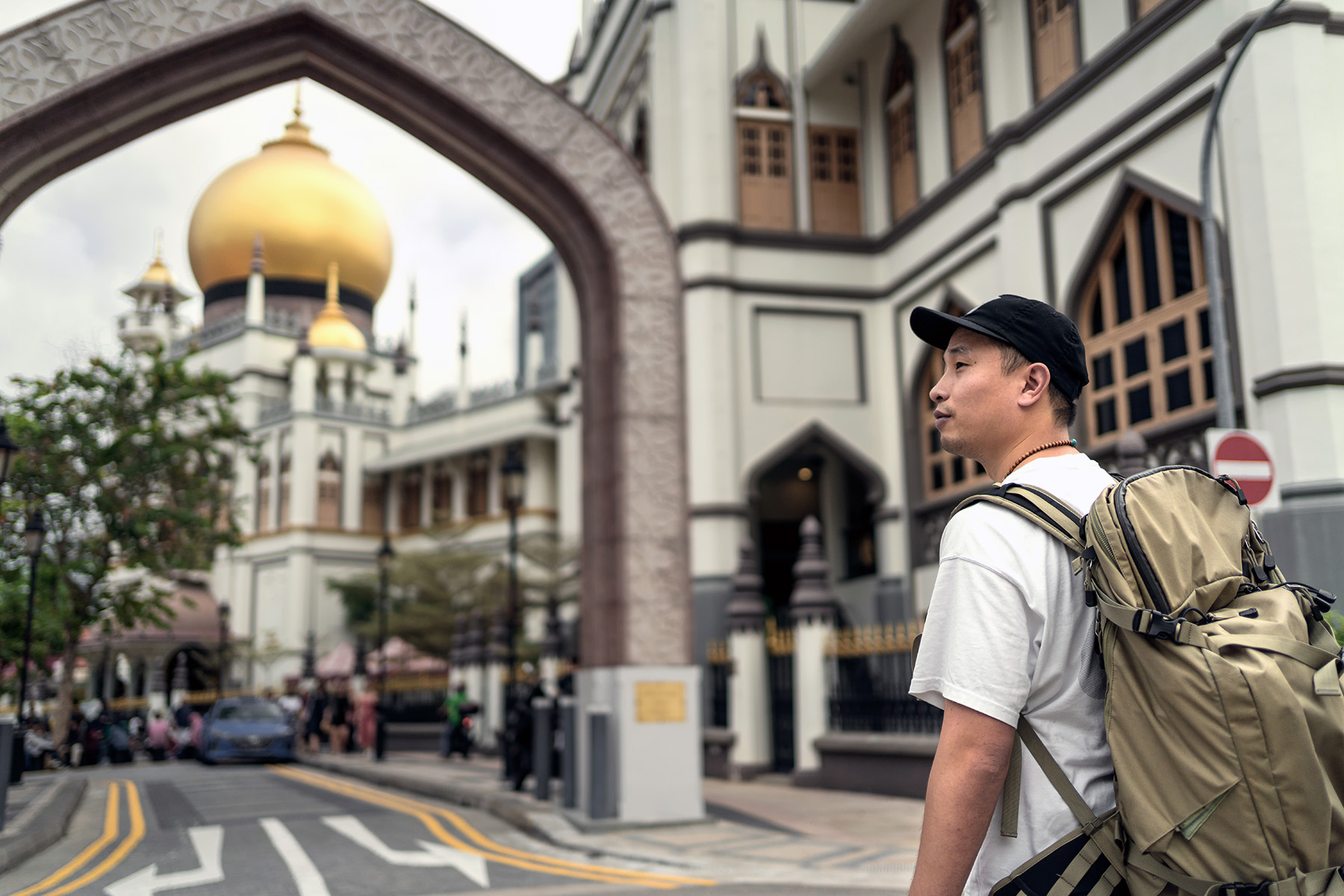 Tourist with a backpack looking around the area of the Sultan Mosque in Singapore.