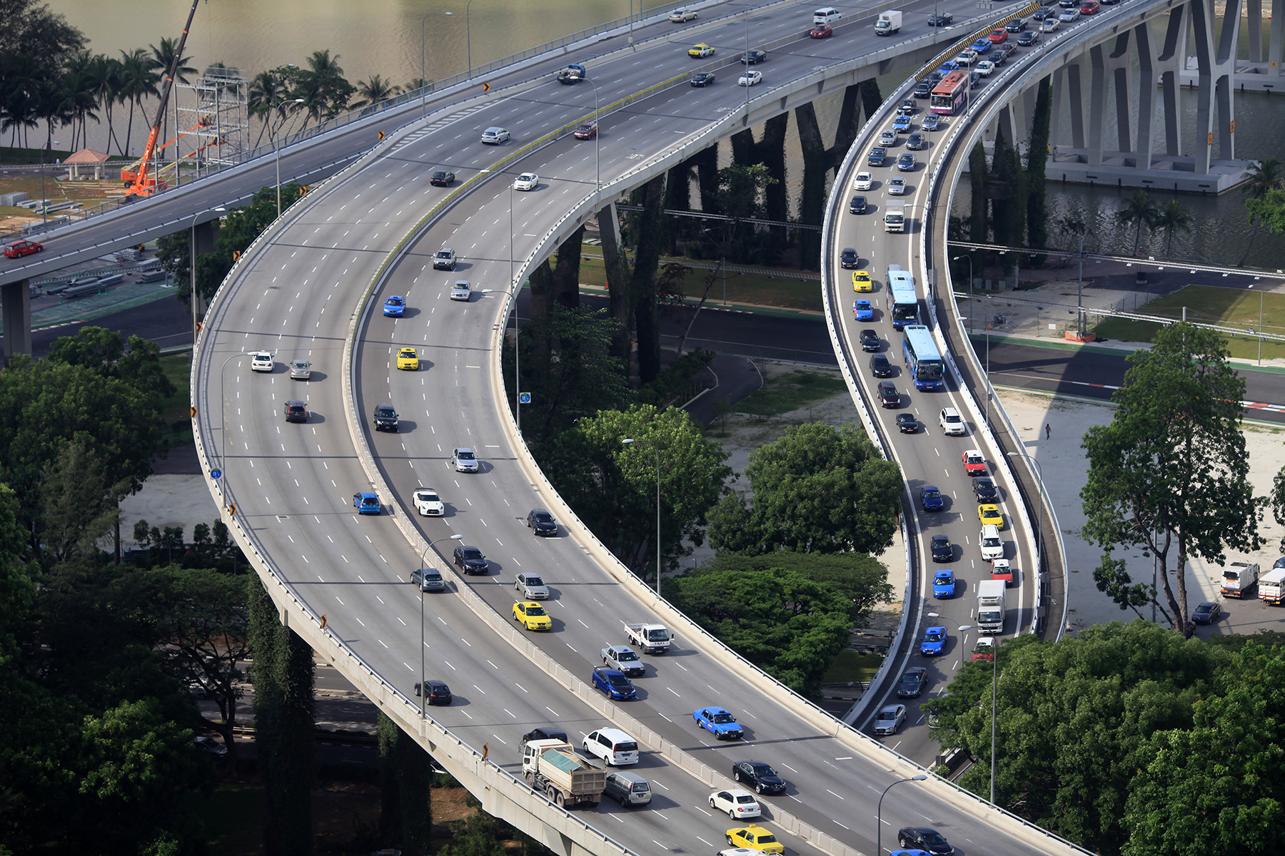 Cars driving along a highway in Singapore. Two lanes are alright, doable, one is congested.