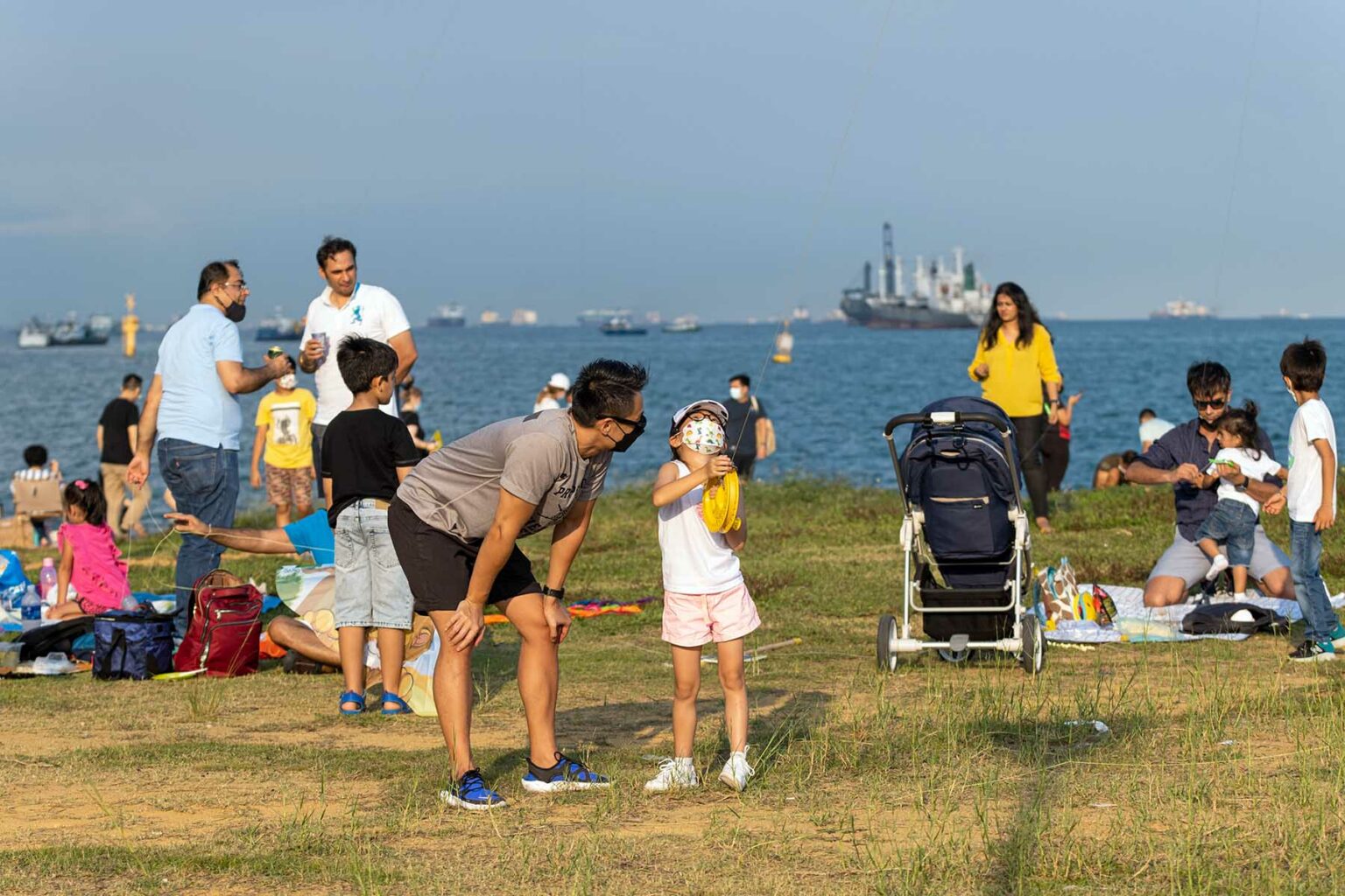 Families are having a picnics and flying kites at Marina Barrage in Singapore