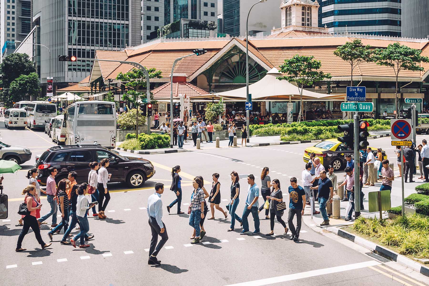 Busy pedestrian crossing on Raffles Quay in Singapore.