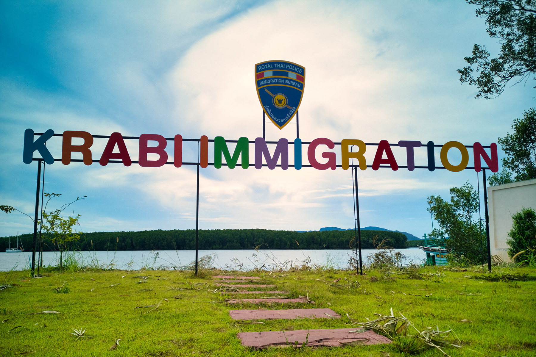 Colorful sign against a blue sky: Krabi Immigration