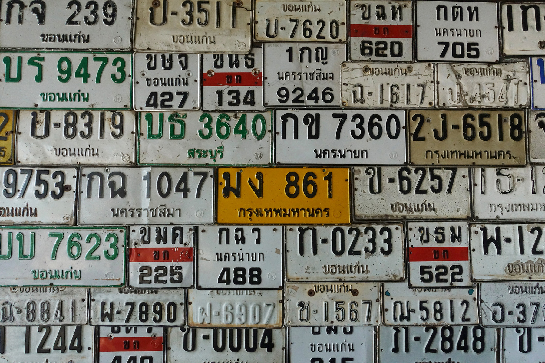 Old Thai license plates displayed on the wall.