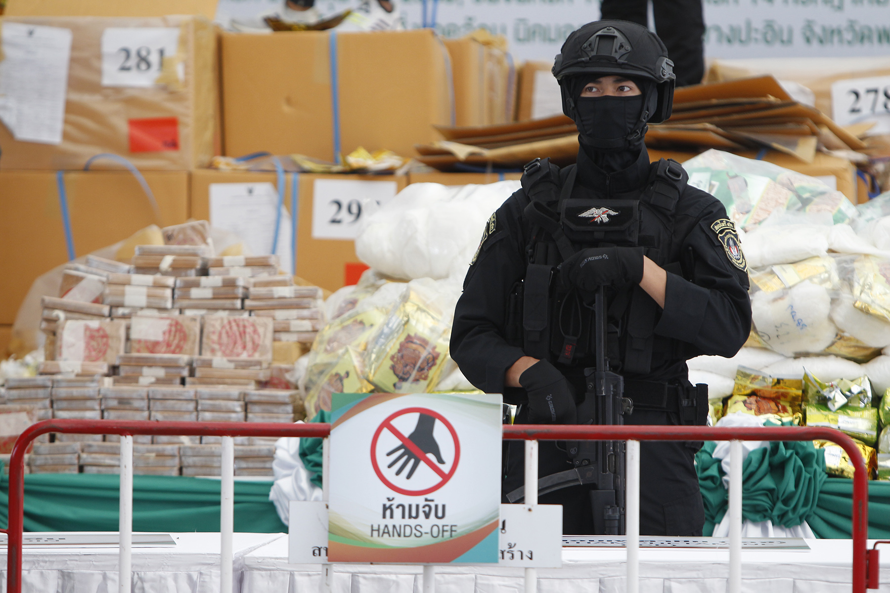 A Thai police officer guards bags of confiscated narcotics drug during the 50th Destruction of Confiscated Narcotics ceremony to mark the International Day Against Drug Abuse and Illicit Trafficking.
