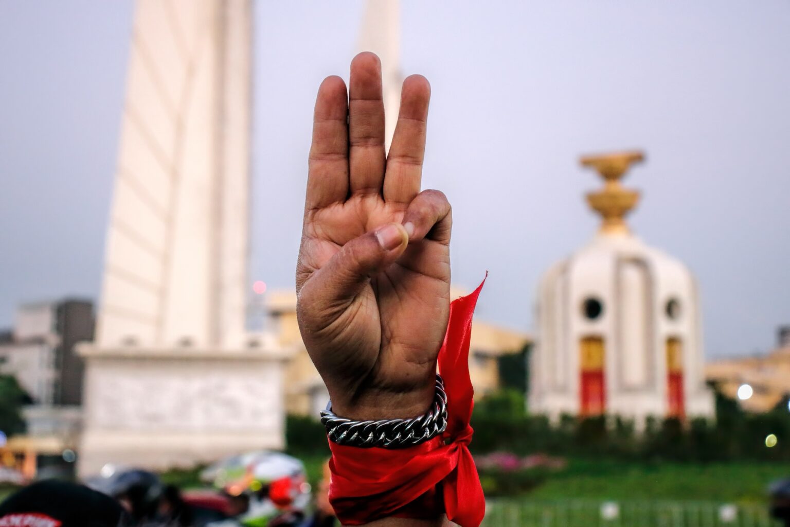 A close-up shot of the three-finger salute in front of the Democracy Monument in Bangkok, Thailand