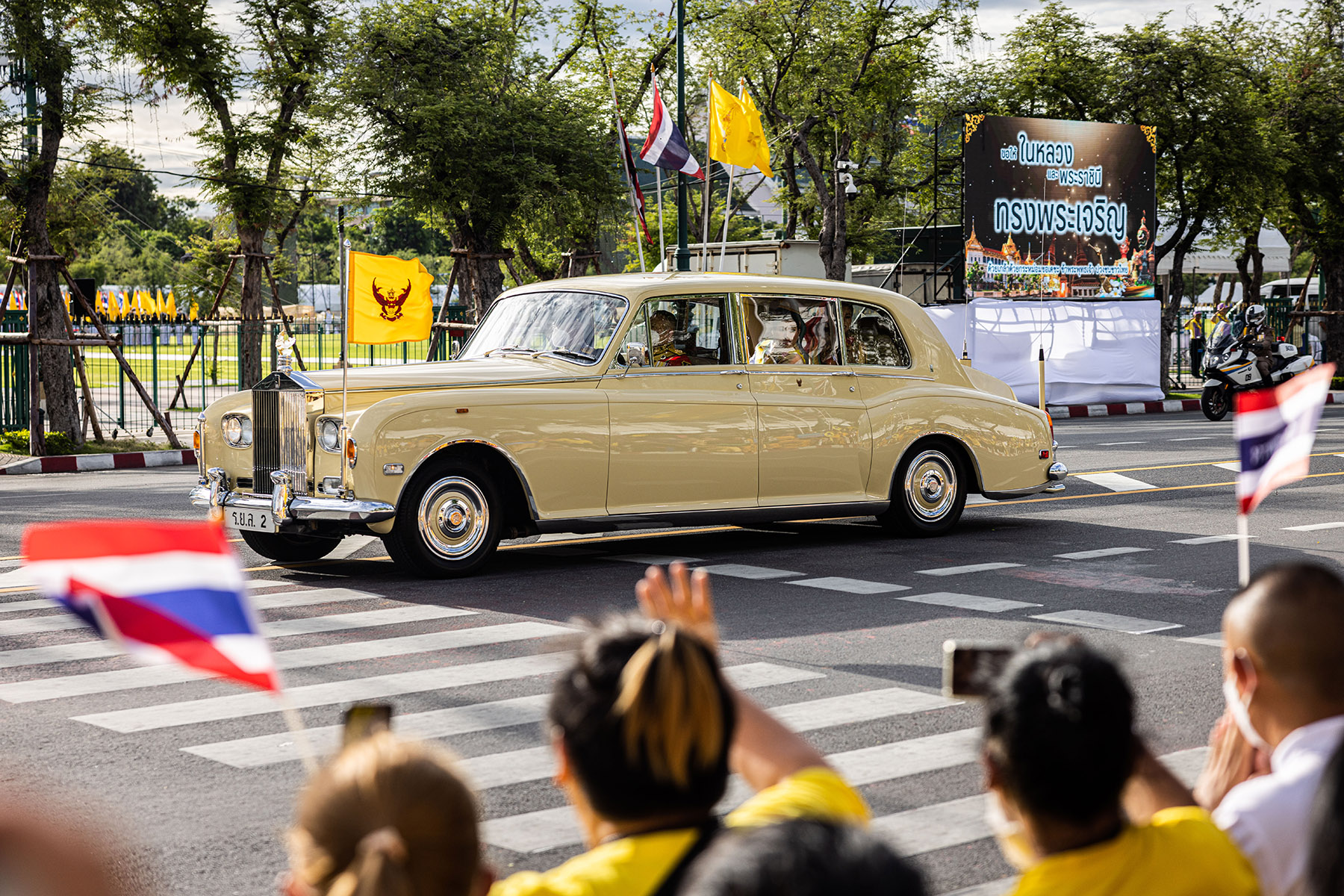 Royal family waves at crowd from motorcade, observing King Maha Vajiralongkorn's 71st birthday