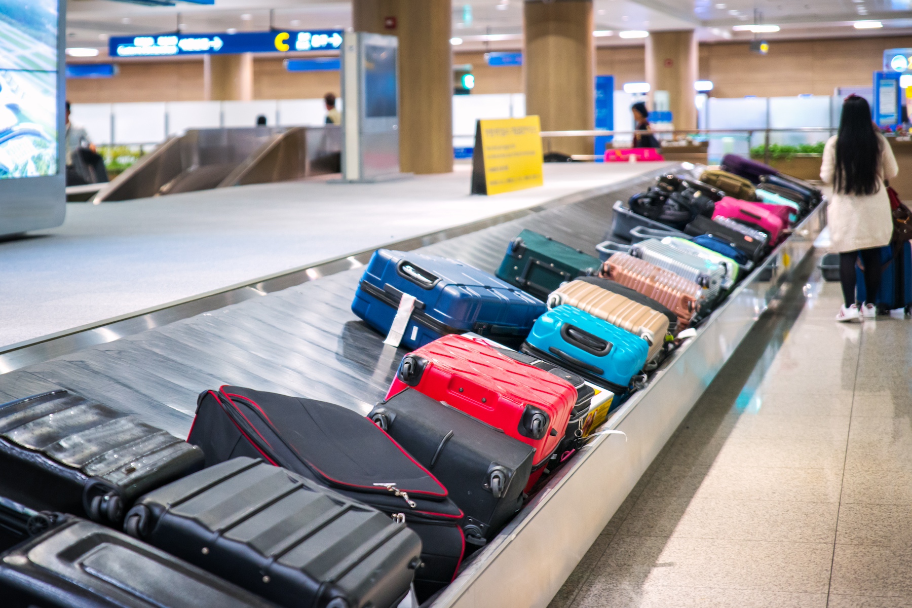 Many travel bags sit on a baggage claim belt at the airport