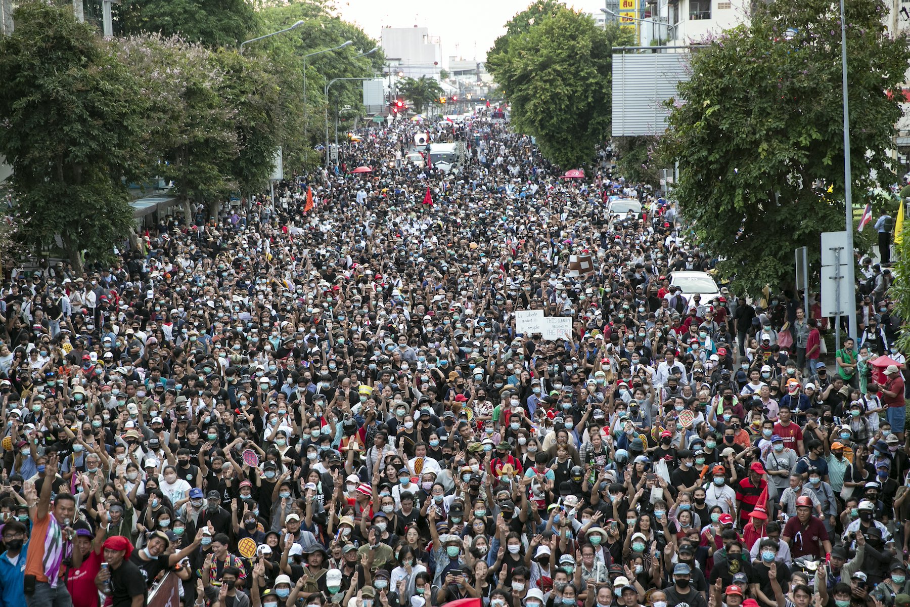 A huge crowd of protesters marches down the street in Bangkok, Thailand