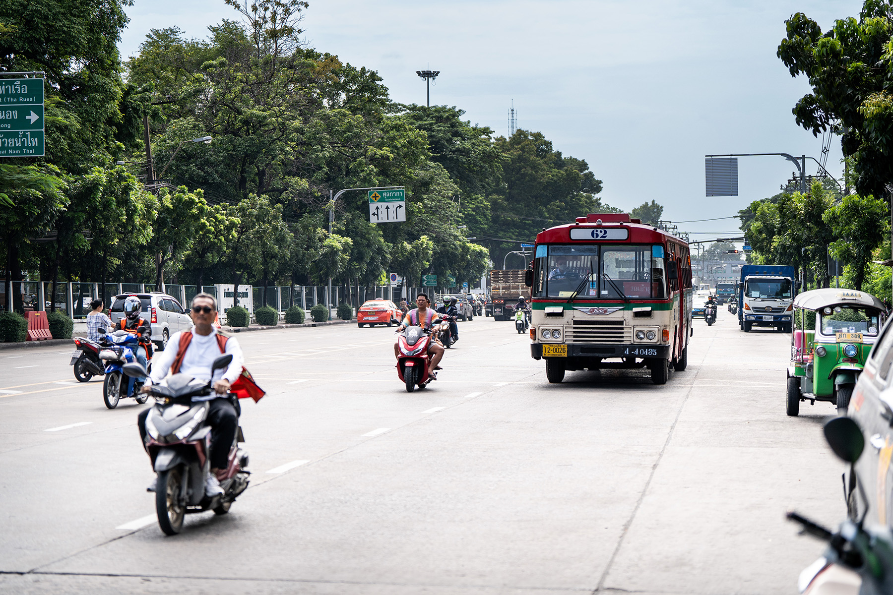 Buses, taxis, mopeds, and tuk-tuks on the street