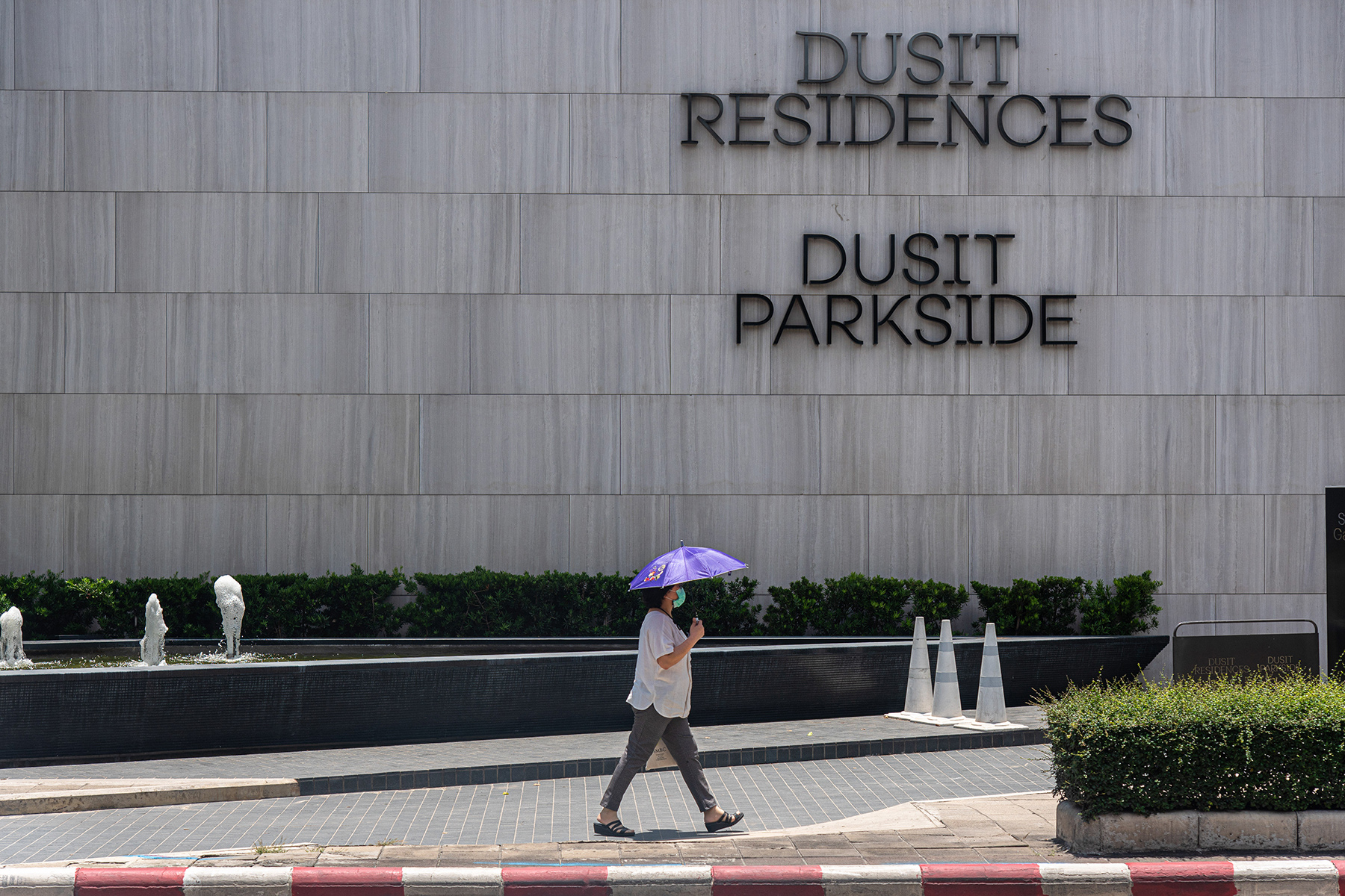 Woman walking past Dusit Parkside luxury condos in Bangkok