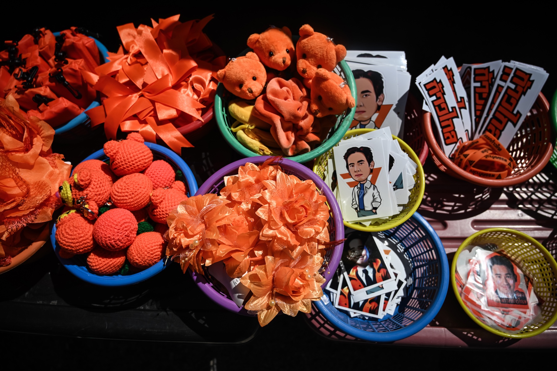Bright orange Move Forward party souvenirs featuring images of Pita Limjaroenrat organized in baskets