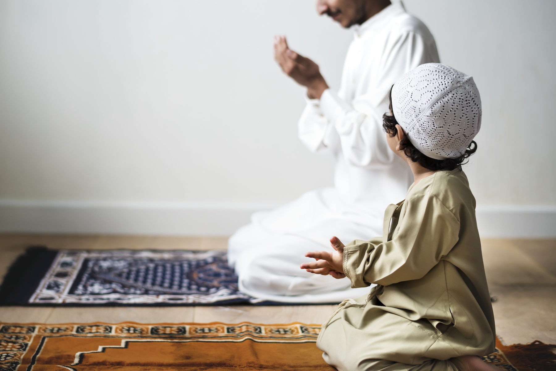 A little boy prays alongside his father during Ramadan