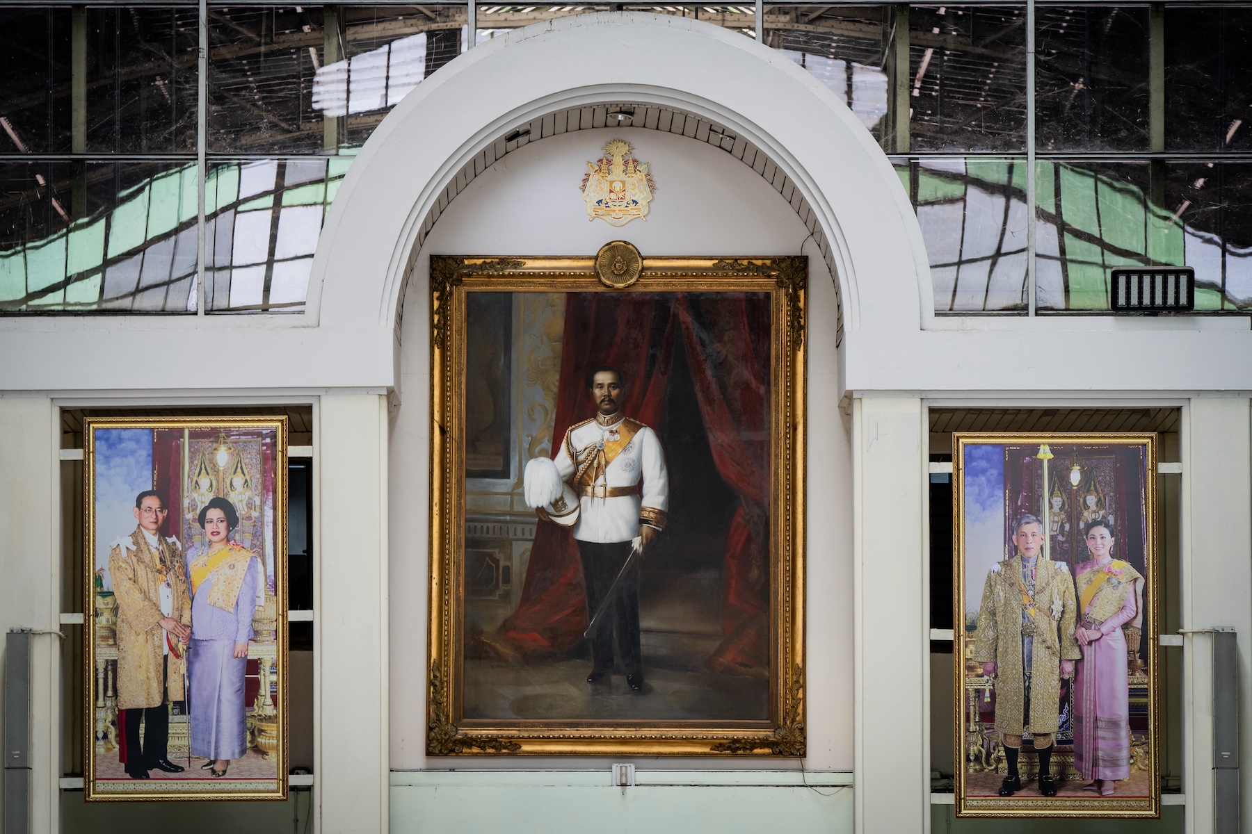 Portraits of King Bhumibol Adulyadej with Queen Sirikit, King Chulalongkorn, and King Vajiralongkorn with Queen Suthida are seen hanging in Hua Lamphong Railway Station