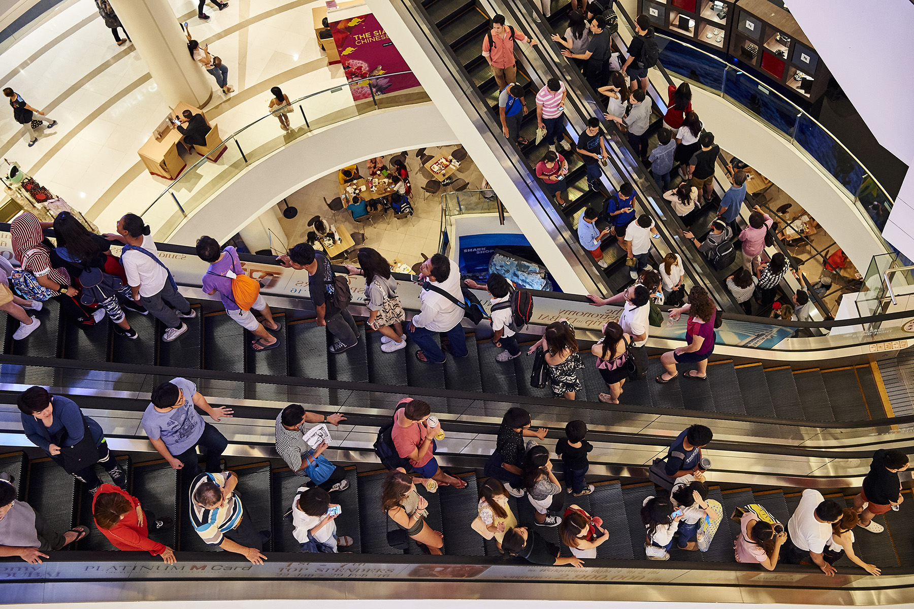 People on escalators in Siam Paragon shopping mall in Bangkok, Thailand

