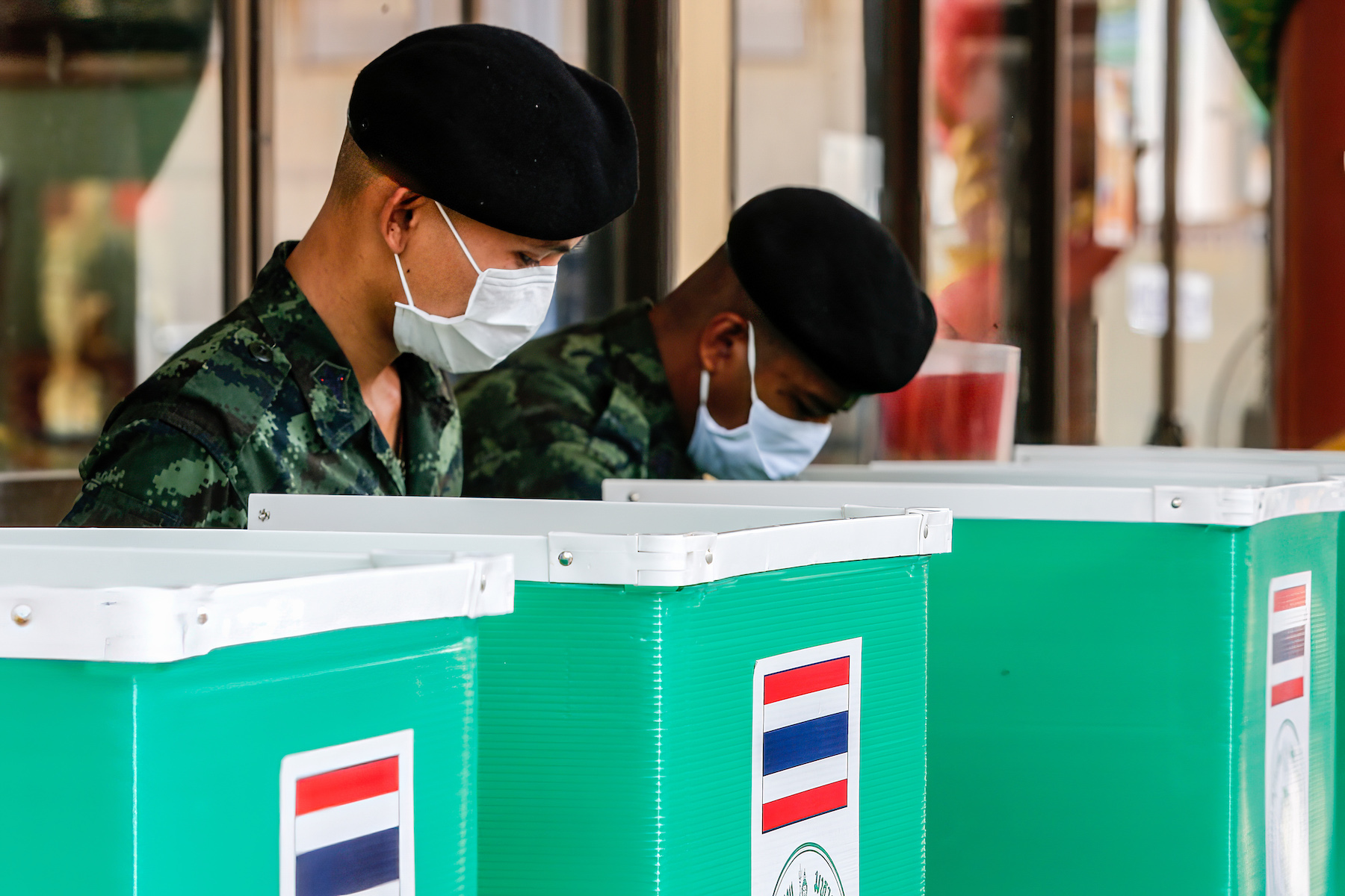 Two members of the Thai military cast their votes in the general election at a polling station