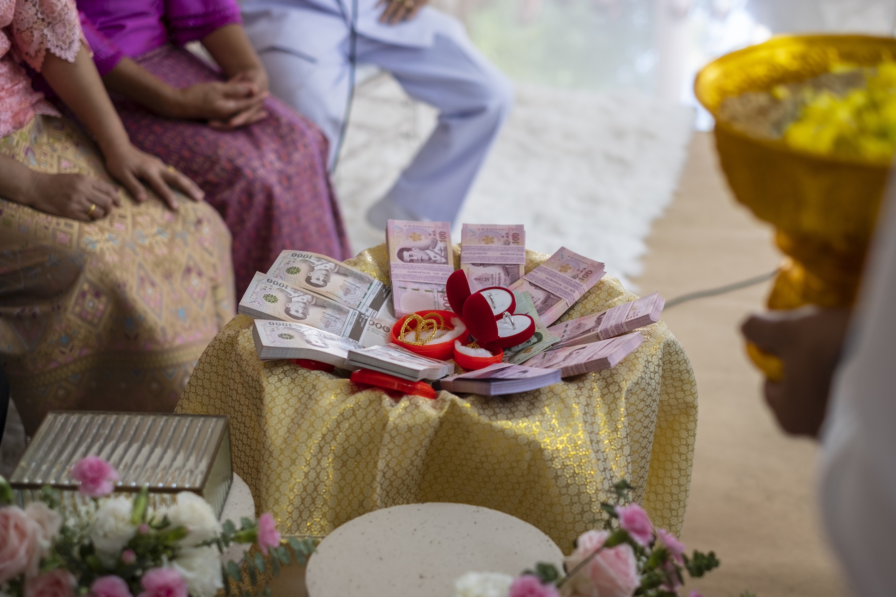 Close-up of a dowry displayed at a Thai wedding, with stacks of baht and jewelry