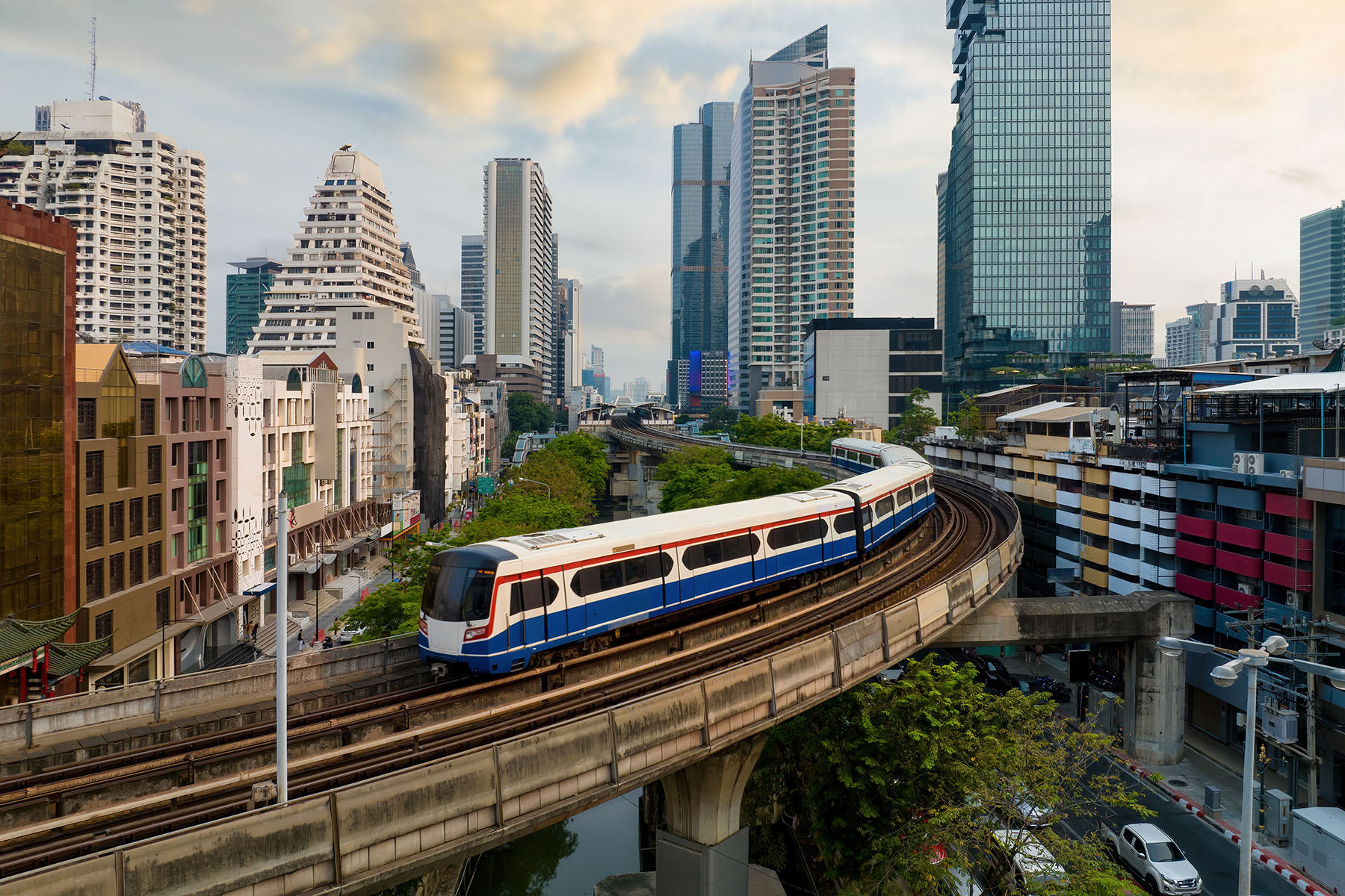 Aerial view of BTS sky train in city across traffic in business area in Bangkok, Thailand.