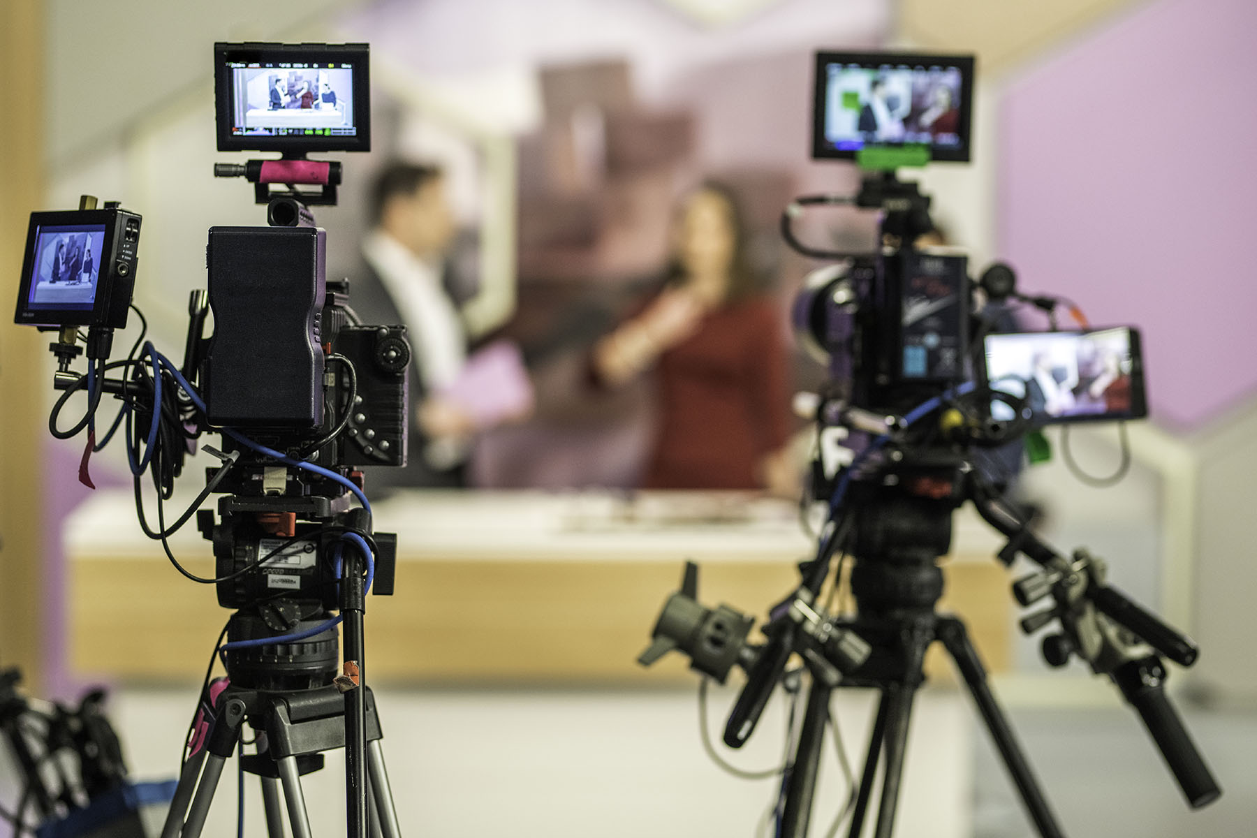 Rear view of two cameras filming an infomercial TV-show.
