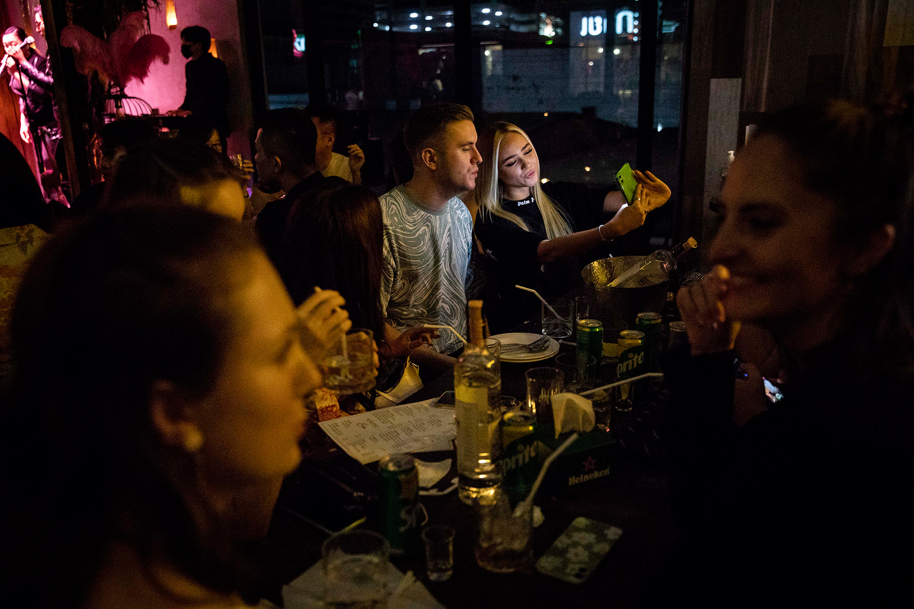 A group of young people in a dark bar