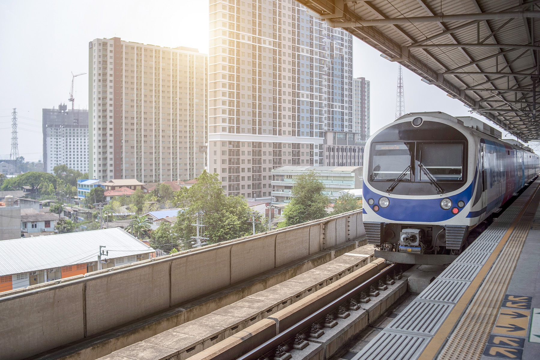 The blue BTS Skytrain stands still on a platform in Bangkok.