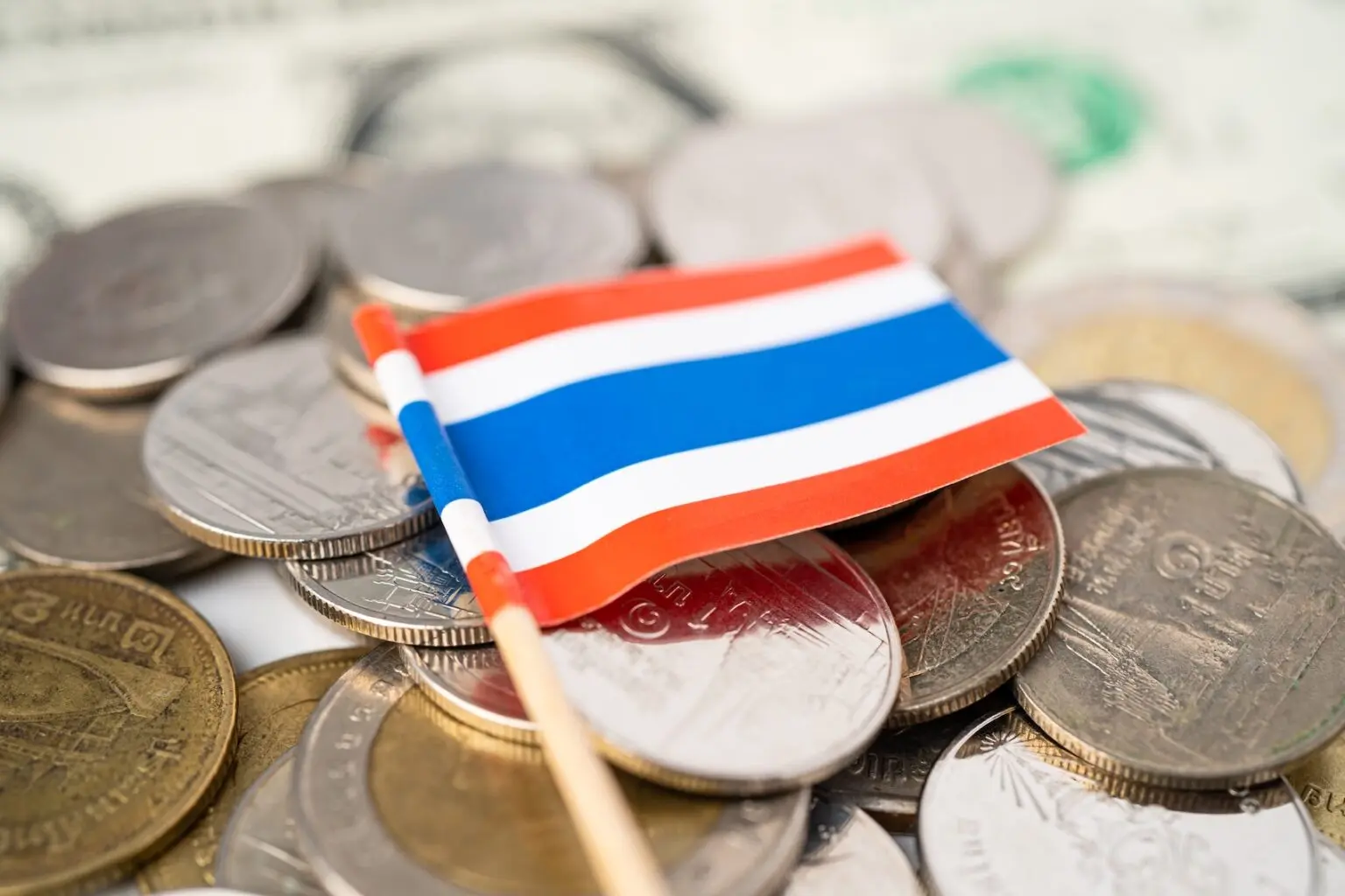 Small Thailand flag placed on Thai baht coins
