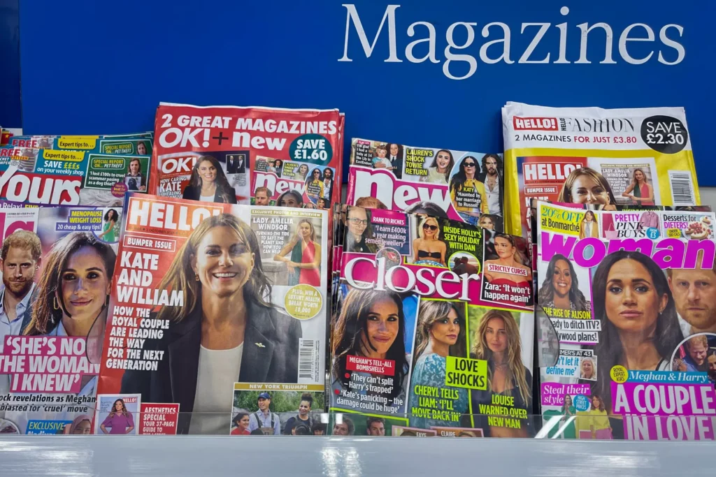 a collection of popular women's magazines displayed on a magazine newsstand in a newsagent shop in the UK
