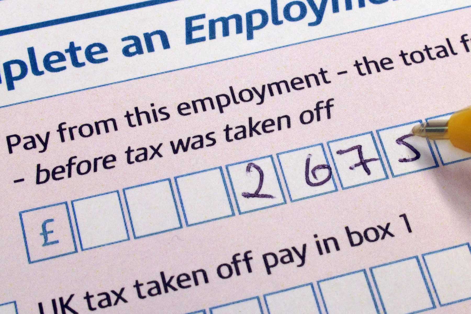 Close-up of a pen in the act of filling in a tax form
