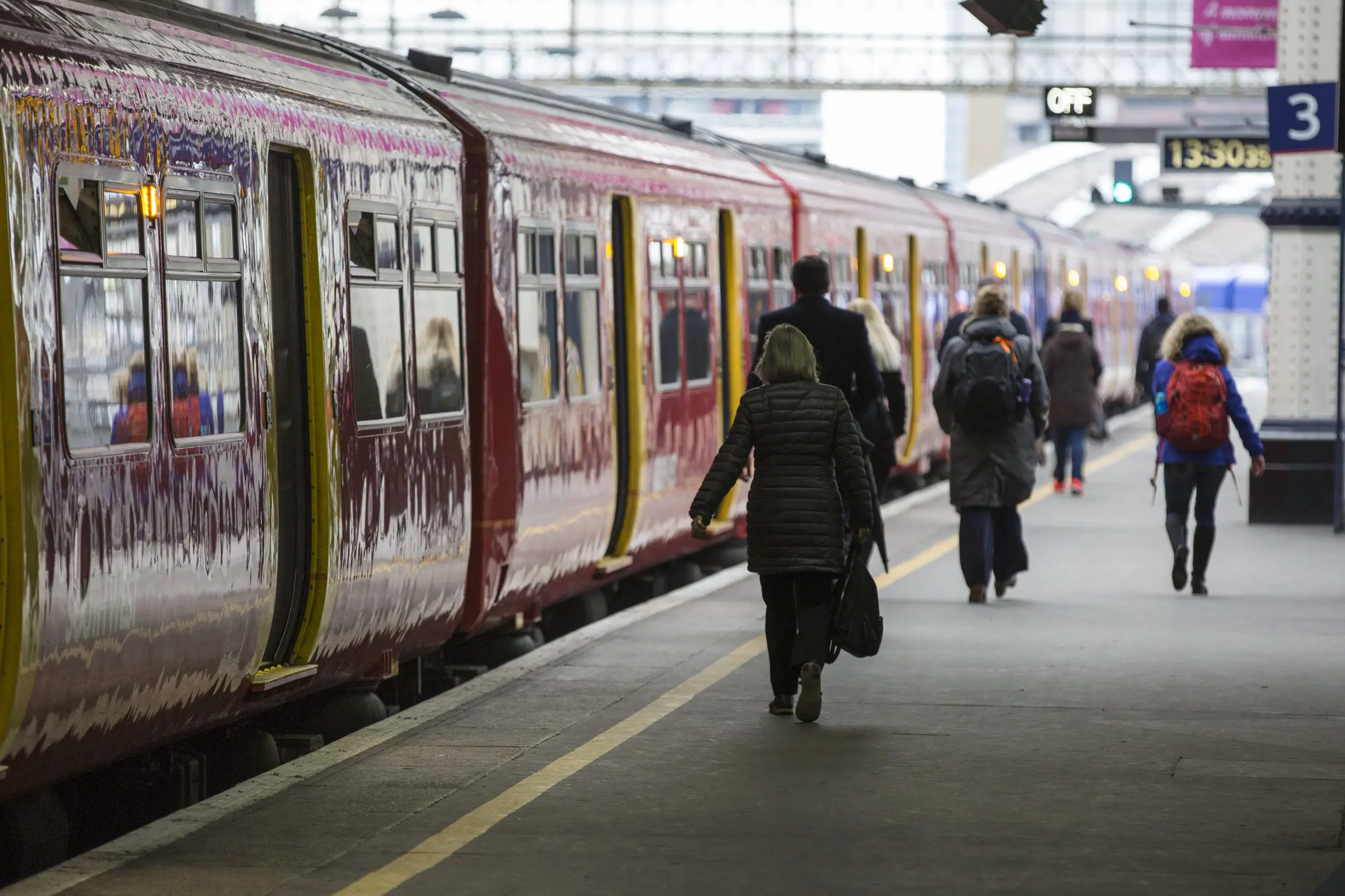 Train on platform with departing passengers at Waterloo Station, London, UK.
