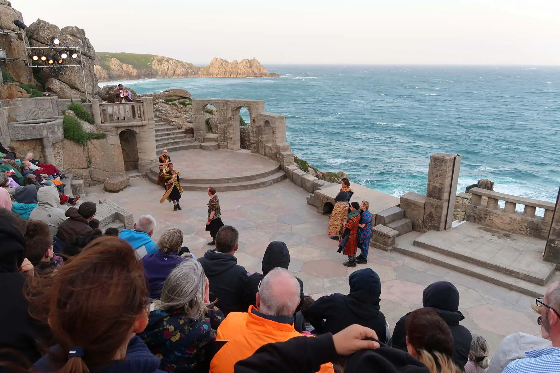 audience watches live performance at clifftop Minack Theatre