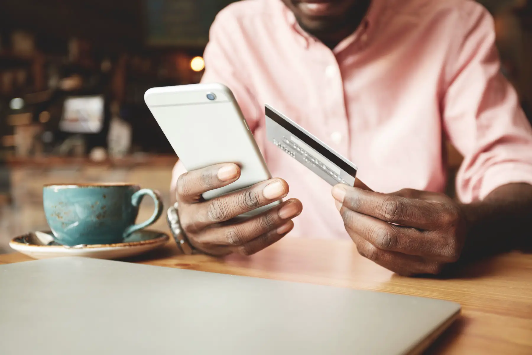 mobile money transfer uk: a man using his mobile and card to transact