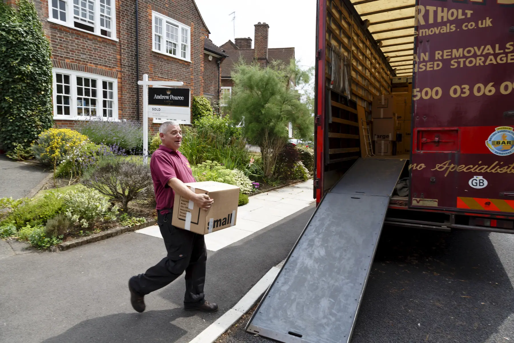 Man packing boxes into a moving van in the UK