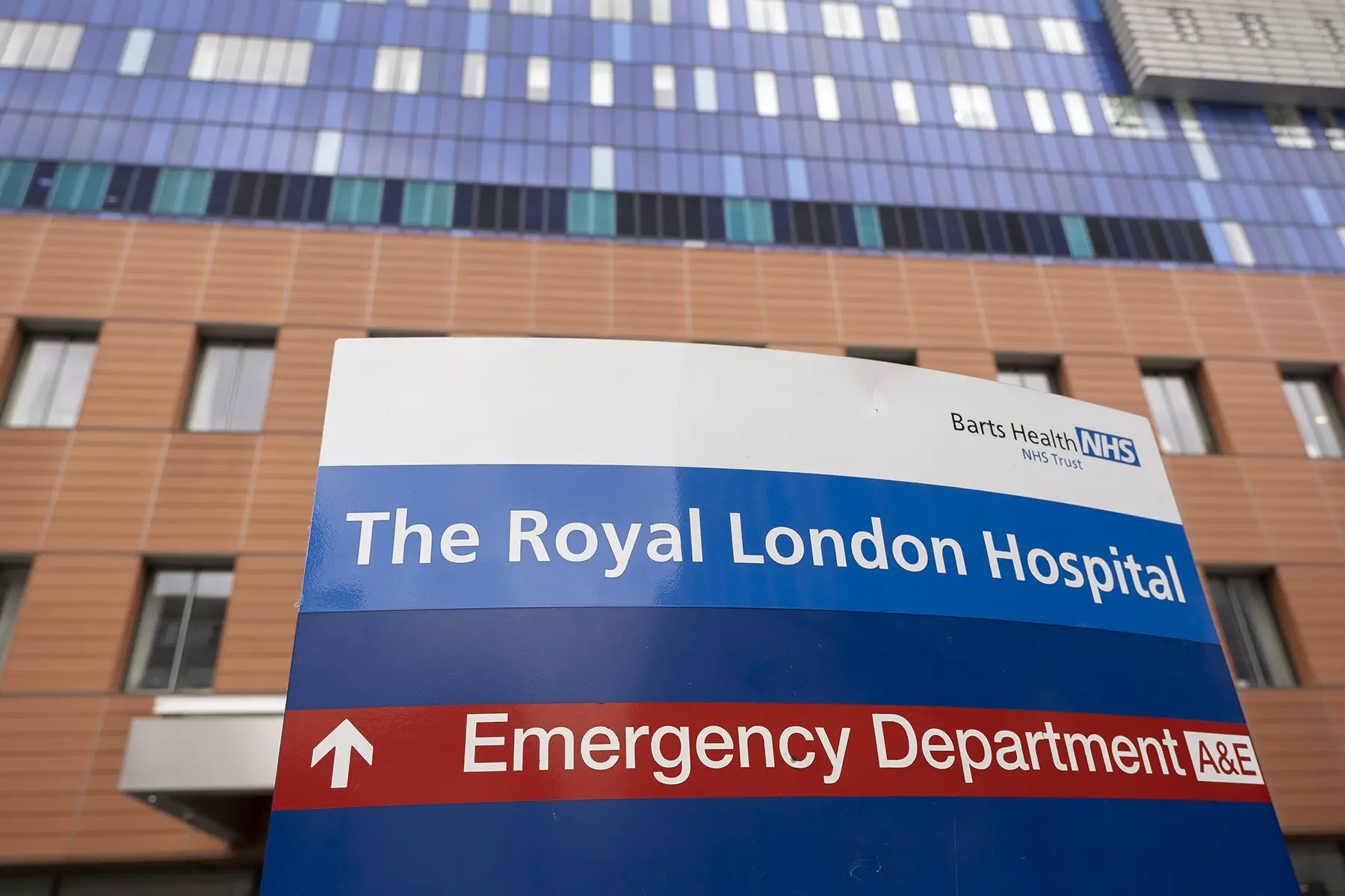The NHS logo on a sign in front of the Royal London Hospital