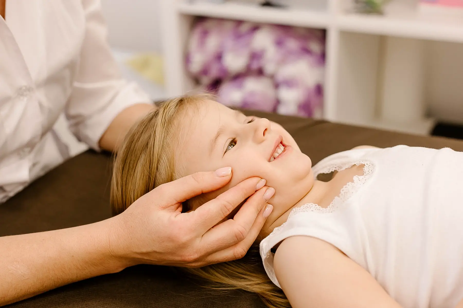 an osteopath doing physiological and emotional therapy with a child patient