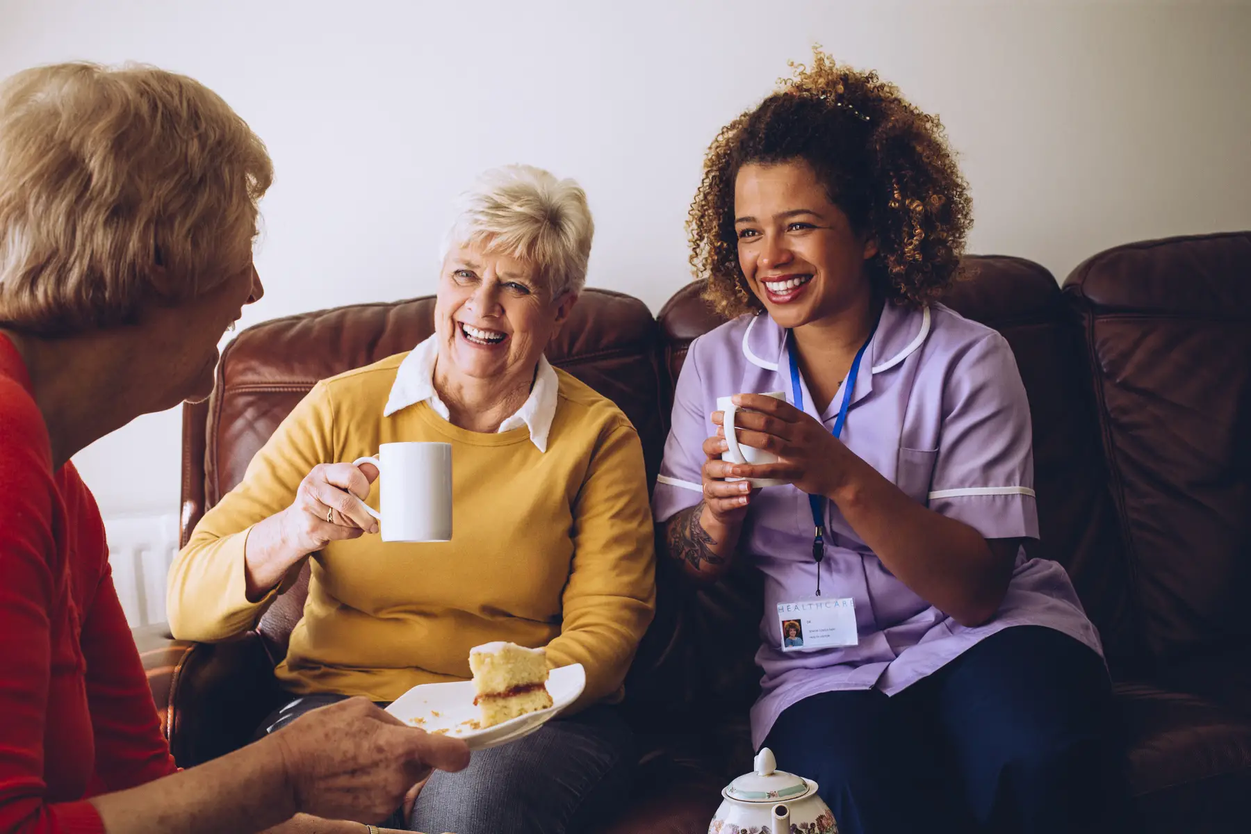 Care at home: care worker sitting with two of her live-in care patients