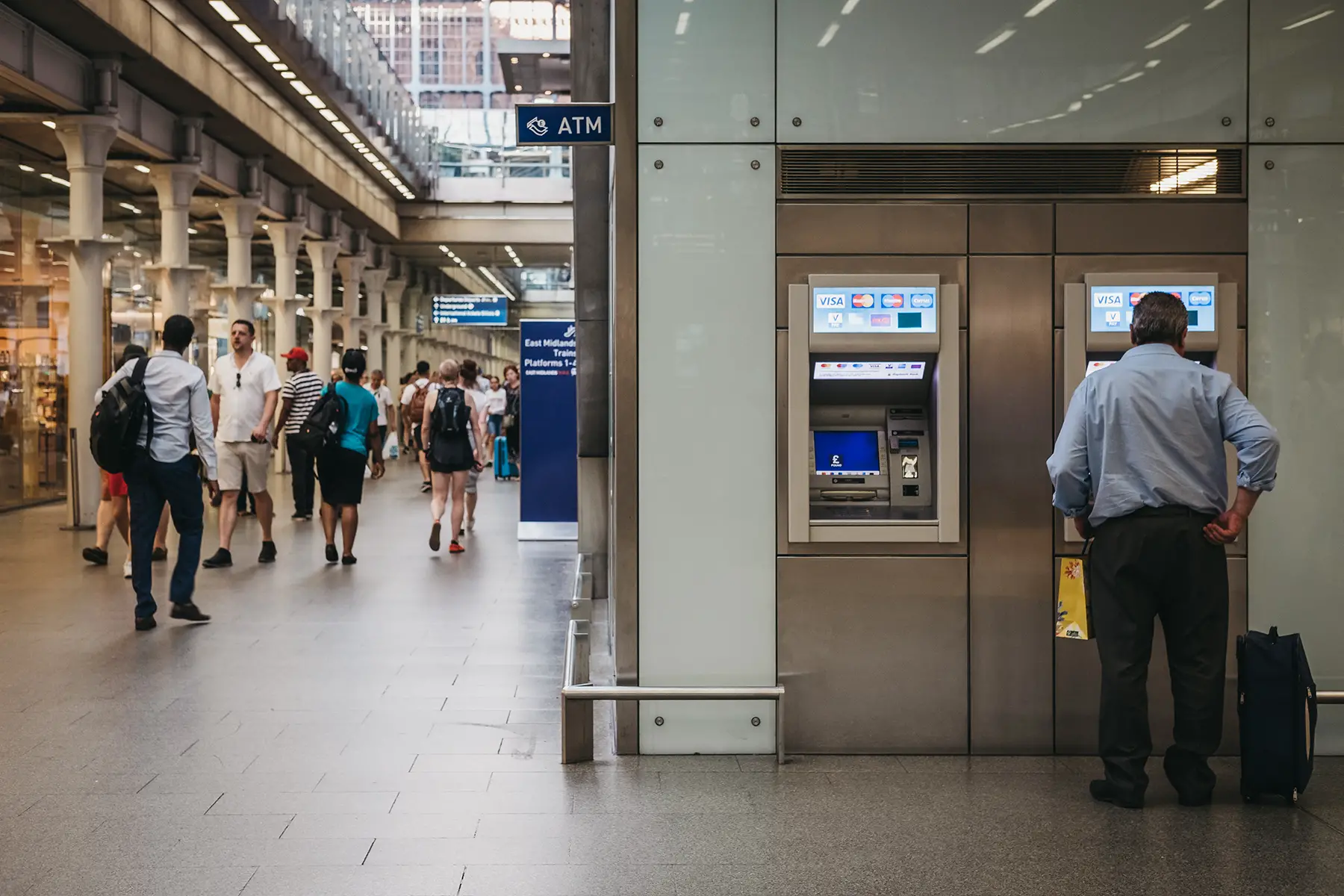 A man uses an ATM at St Pancras station
