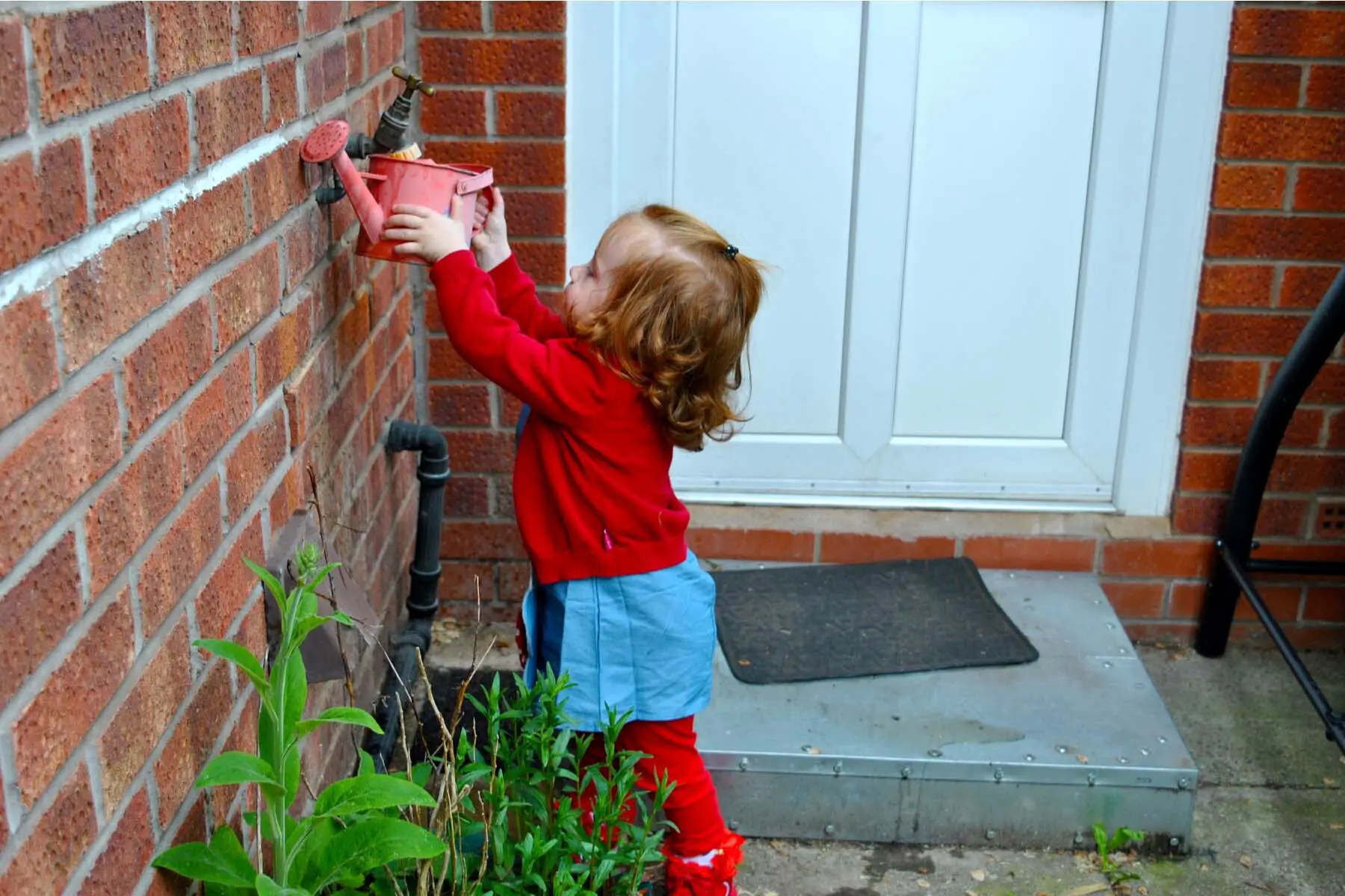 sustainable living in the UK - little girl filling watering can