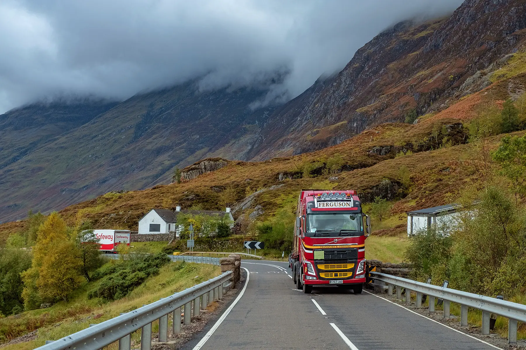 Road freight truck driving through lush scenery in Scotland