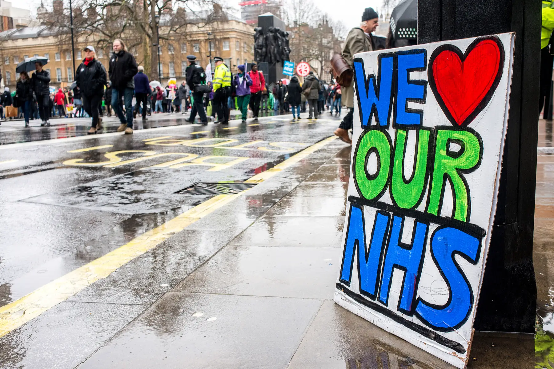WE LOVE OUR NHS poster sits in the rain at the NHS In Crisis demonstration in central London