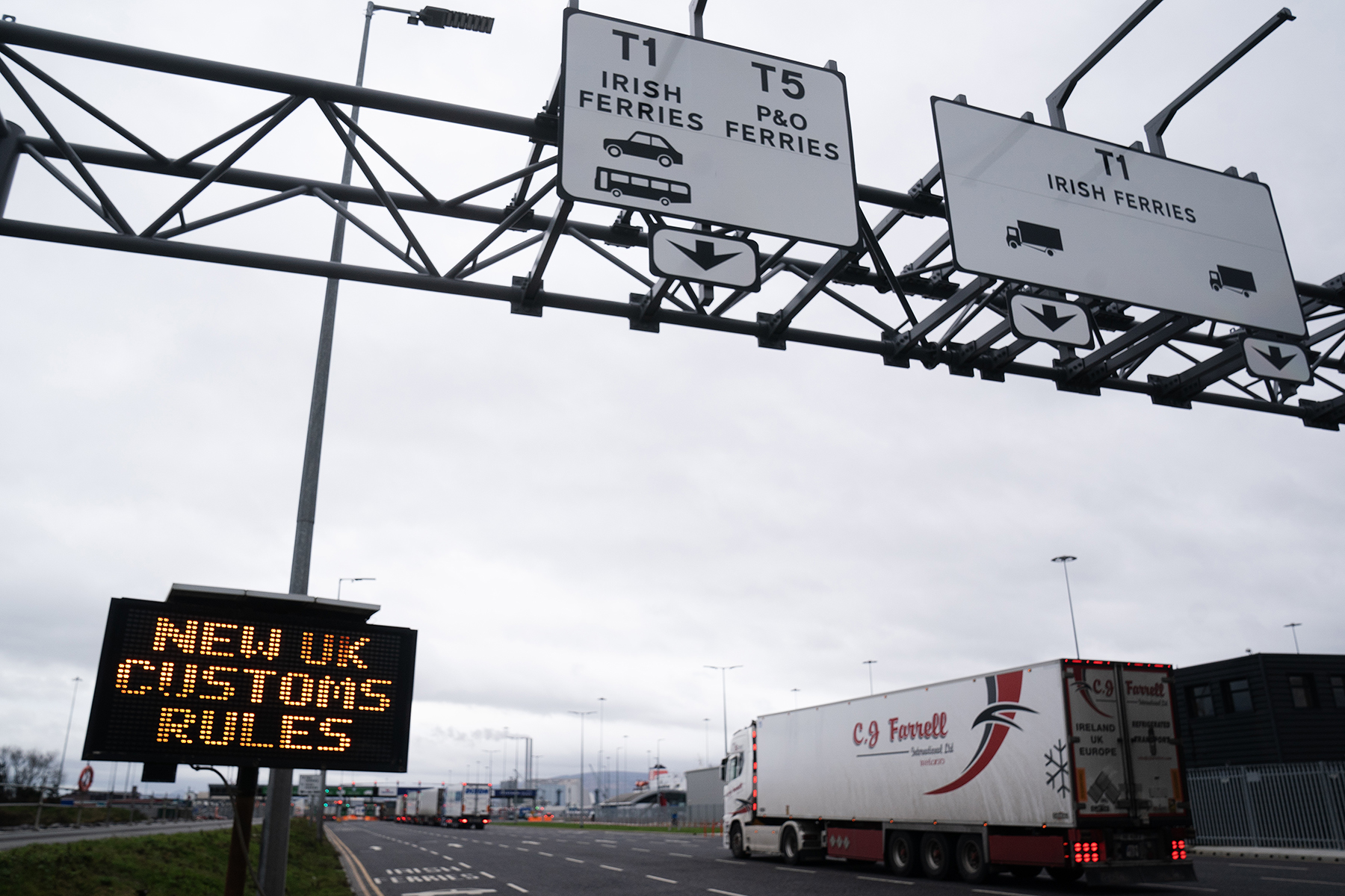 View of a road at Dublin port with lorries and a sign reading 'New UK customs rules'