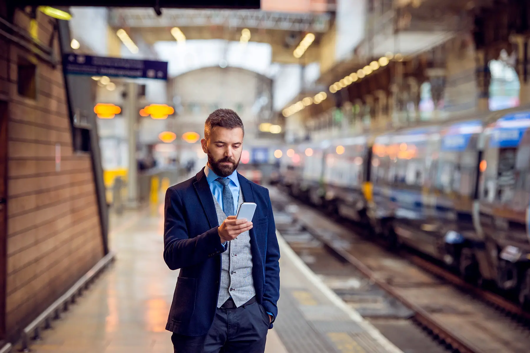 Businessman using his phone in a metro station