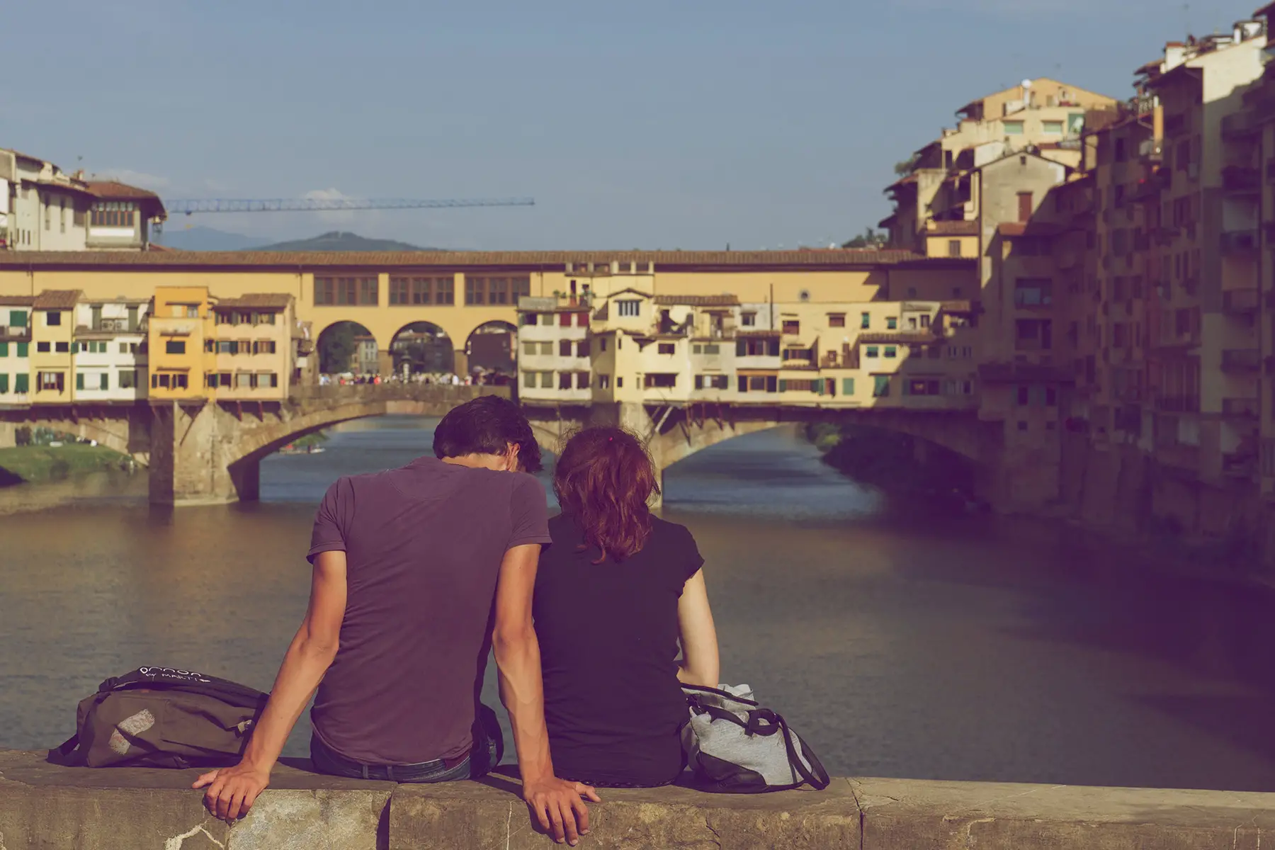 A couple sitting on a bridge in Firenze